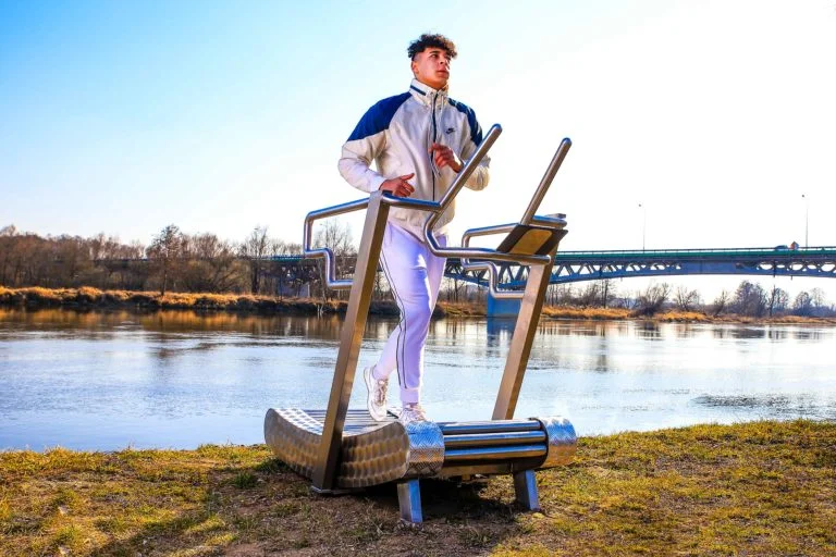 A man is jogging on an outdoor treadmill