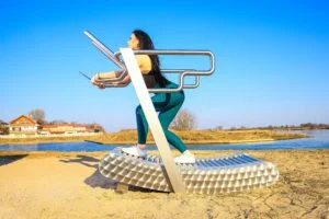 a woman exercises on the iGreenMill outdoor treadmill by the water