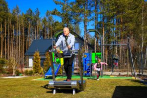 An elderly man exercises on an outdoor treadmill