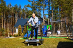 An elderly man exercises on an outdoor treadmill, second image